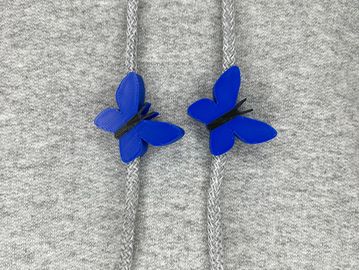 Blue butterfly sweatshirt charms on a grey sweatshirt