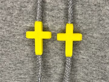 Yellow cross charms on sweatshirt drawstrings