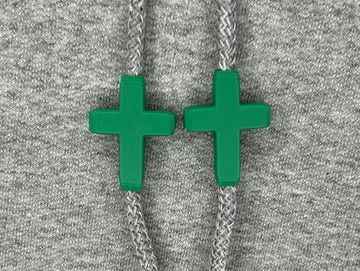 Green cross charms on sweatshirt drawstrings