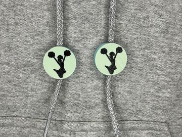 Silhouetted cheerleader charm  in black and light teal on sweatshirt drawstring.