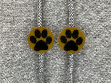 Brown and black paw print charms on sweatshirt drawstring.