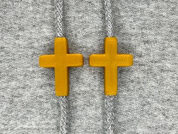 Gold cross charms on sweatshirt drawstrings