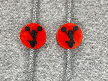 Silhouetted cheerleader charm in red and black on sweatshirt drawstring.