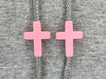Pink cross charms on sweatshirt drawstrings