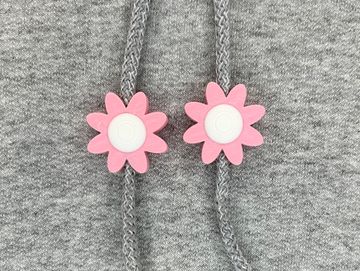 Pink and white flower sweatshirt charms on a grey sweatshirt
