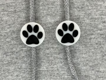 White and black paw print charms on sweatshirt drawstring.