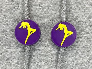 Silhouetted dance charm in purple and gold on sweatshirt drawstring.
