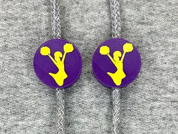 Silhouetted cheerleader charm in purple and gold on sweatshirt drawstring.