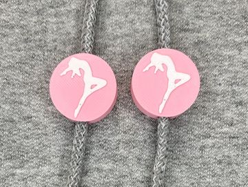 Silhouetted dance charm in pink and white on sweatshirt drawstring.