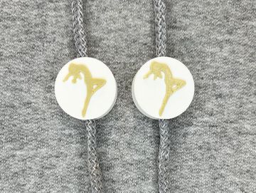 Silhouetted dance charm in white and vegas gold on sweatshirt drawstring.