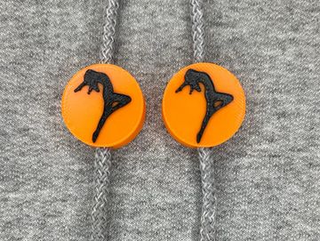 Silhouetted dance charm in orange and black on sweatshirt drawstring.