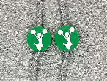Silhouetted cheerleader charm in kelly green and white on sweatshirt drawstring.