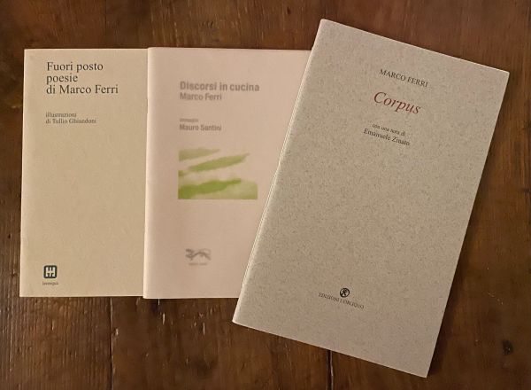 Tre libri di Marco Ferri posati su tavola di legno