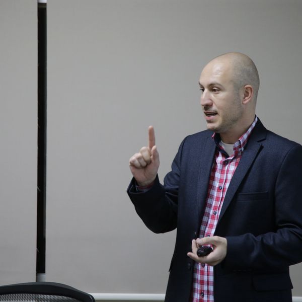 Man giving a presentation while gesturing with his finger.