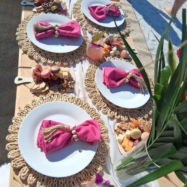 Elegant outdoor table setting with pink napkins and charcuterie boards.