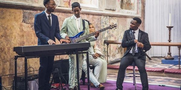 Three men in suits performing music in a vintage room.