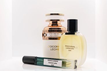 Three elegant perfume bottles on a white surface.