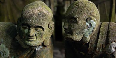 Two ancient stone statues facing each other.