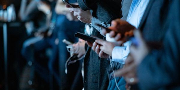 Photos of journalists holding mobile phones at press conference