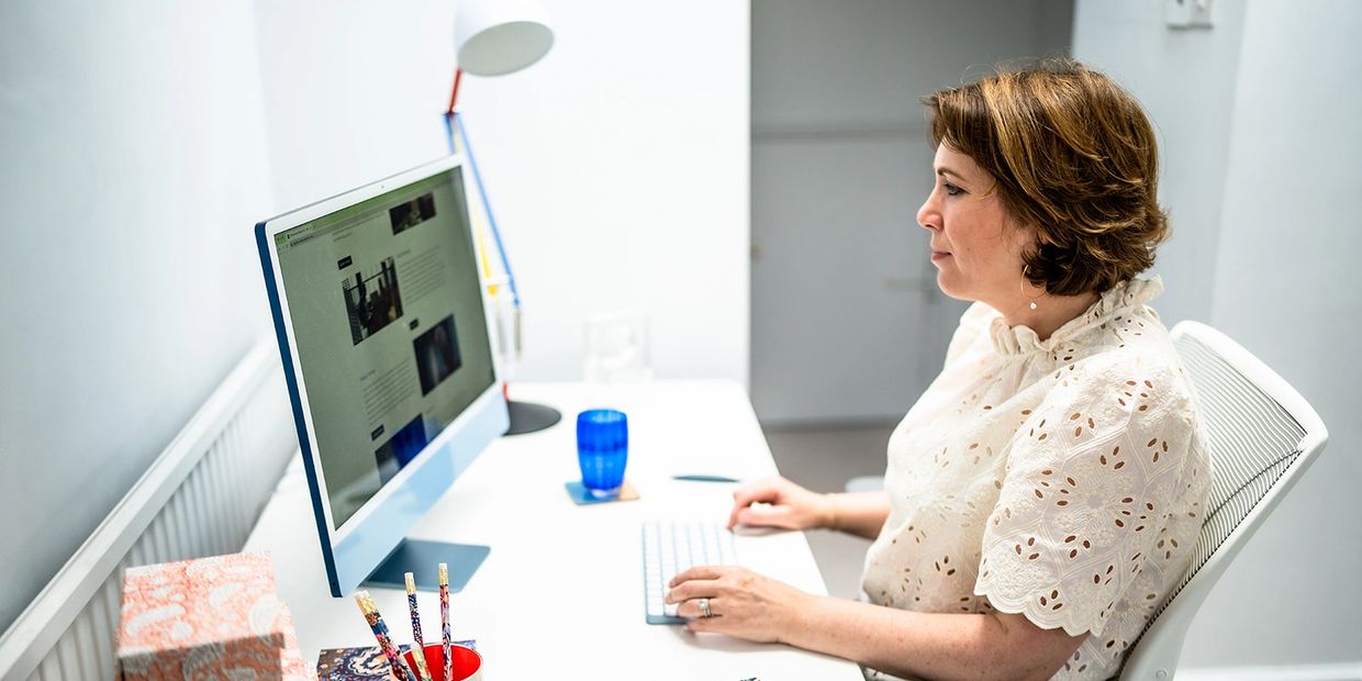 Jane Griffin, founder and director of Positive Story PR consultancy working at a computer.