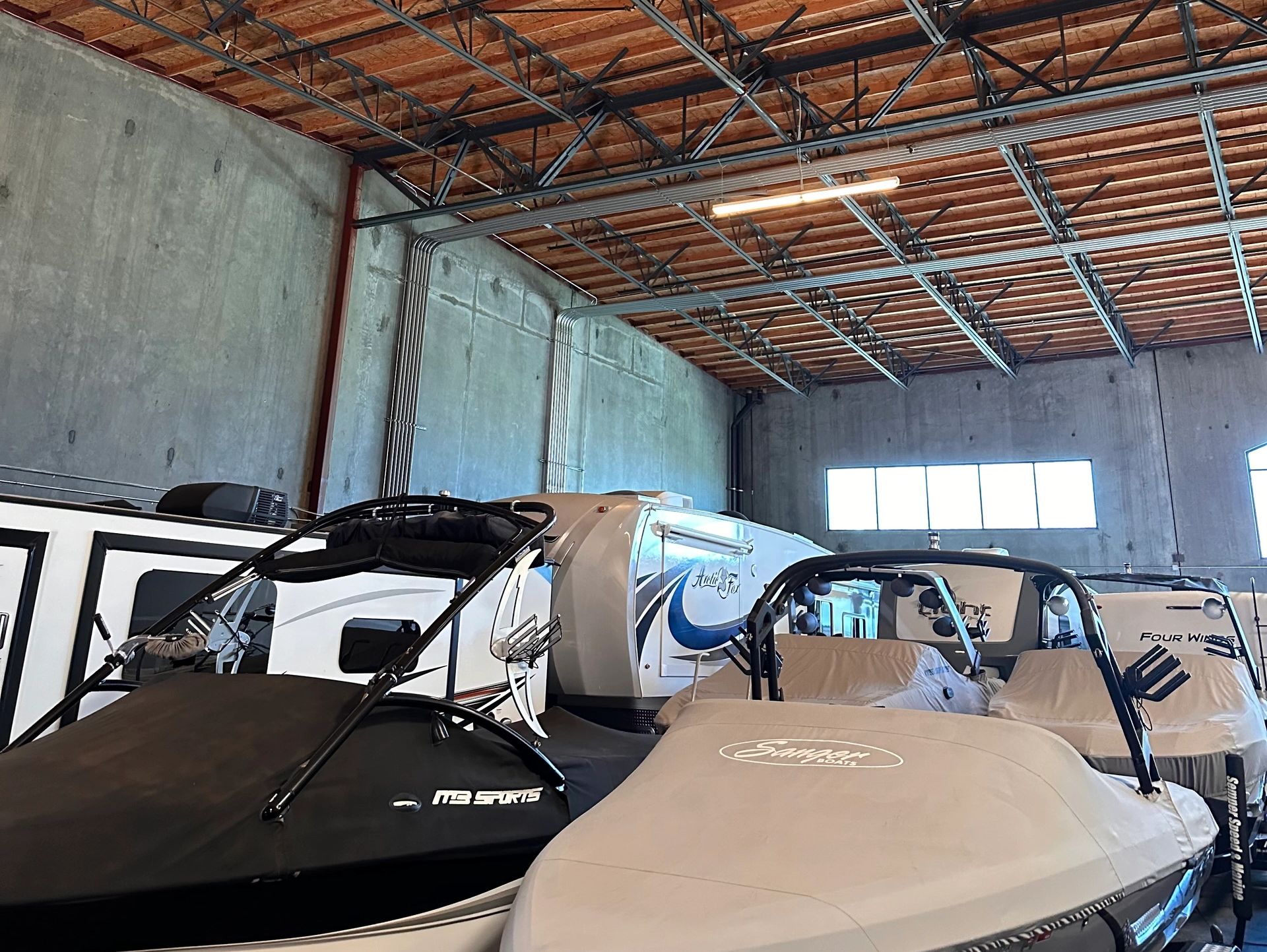 Boats stored inside a large warehouse.