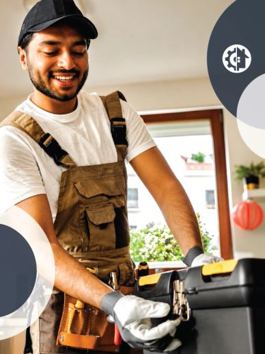 Smiling handyman opening a toolbox indoors.