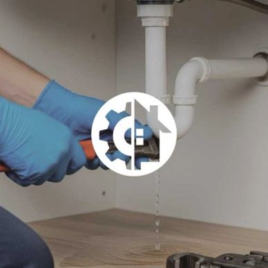 Plumber fixing a leaking pipe under the sink.