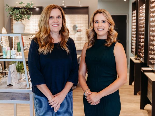Two women standing together in a well-lit store.