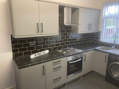 Grey vinyl wrapped kitchen with black white marble. 