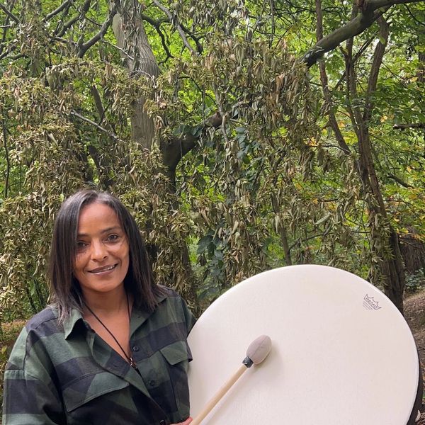 This image Shows the Ceo and Founder Dahni, drumming in the woods.