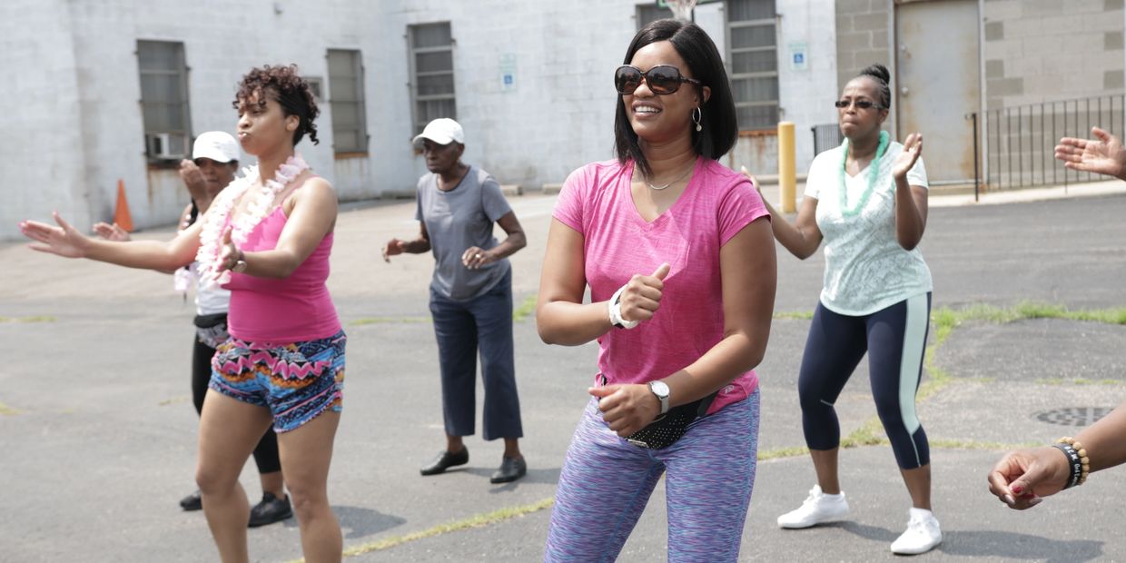 Group of women exercising outdoors, smiling and enjoying the activity.