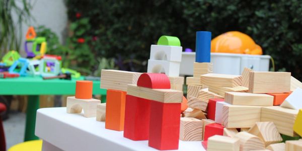 Colorful wooden building blocks arranged on a white table.