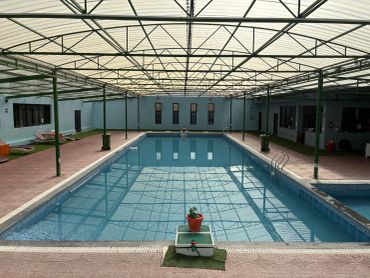 Indoor swimming pool with a glass ceiling.