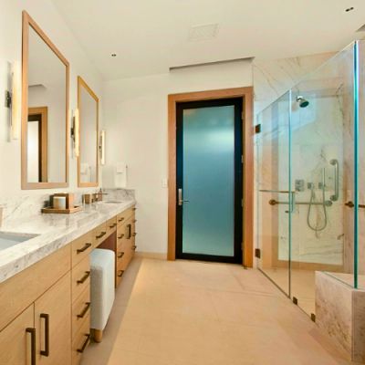 Modern bathroom with double sinks and a glass shower.