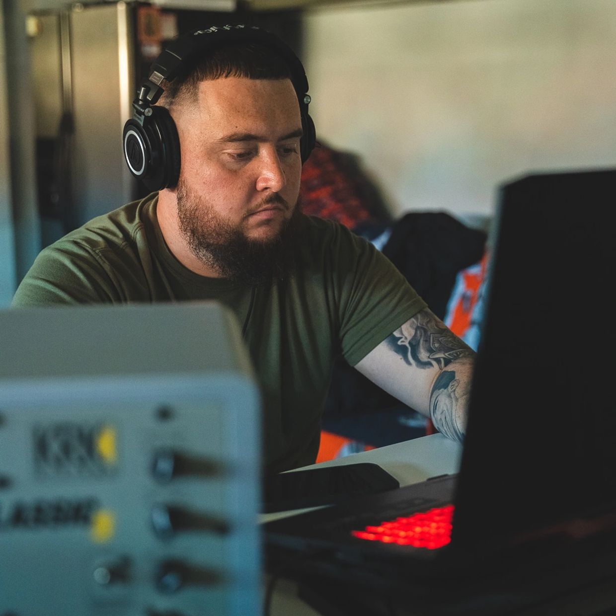 Man with headphones working on laptop.