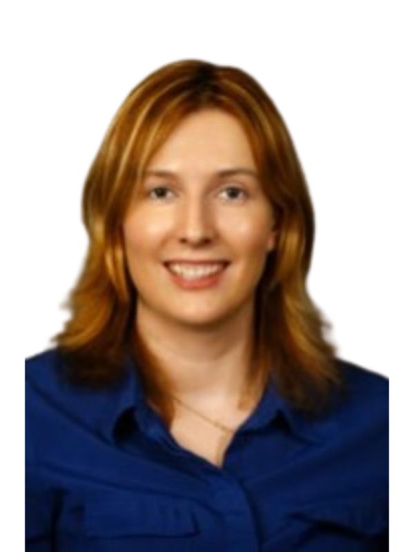Smiling woman with red hair wearing a blue shirt.