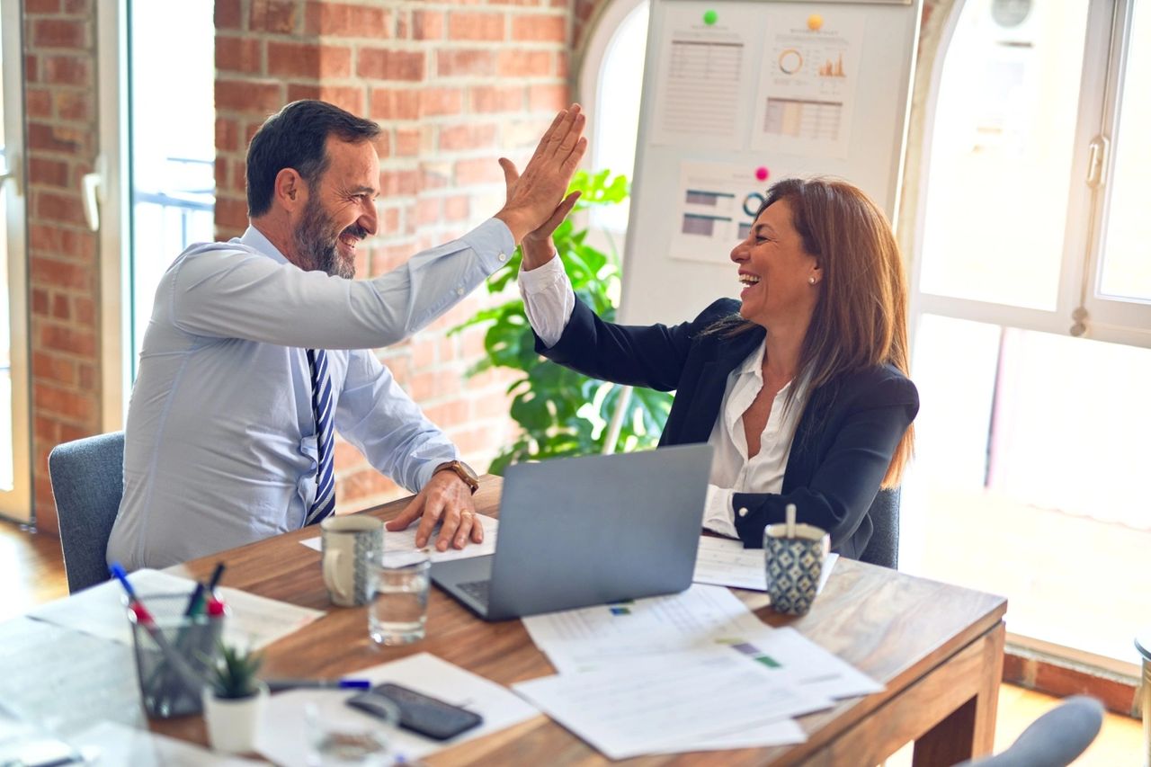 Two people high-fiving happily