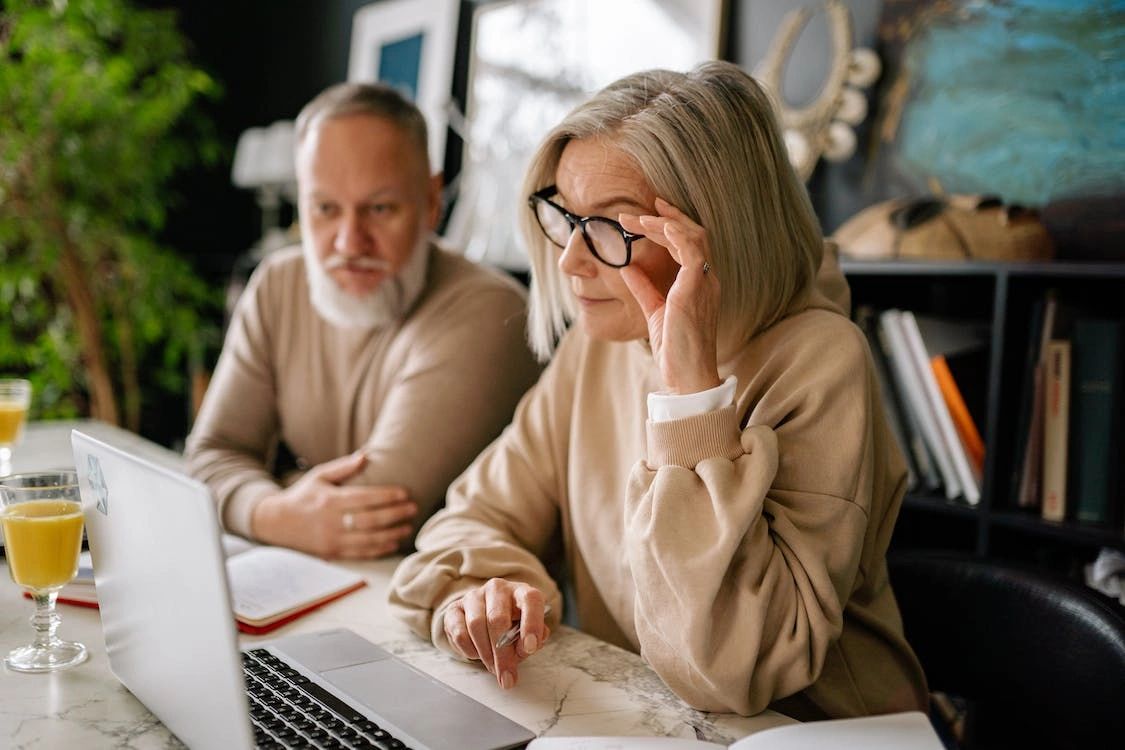 An old couple searching for reliable real estate agents in Dillsburg using a laptop