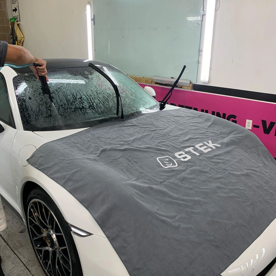 Protective film being applied to a Porsche windshield