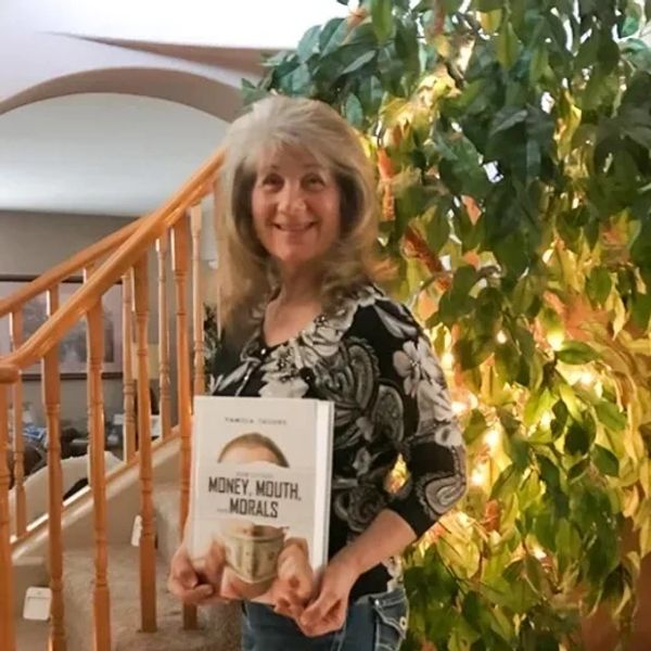 Pamela Tashne is standing by holding the book