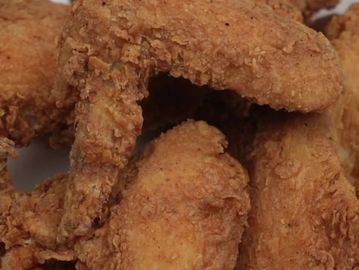 Close-up of crispy fried chicken wings with golden-brown breading.