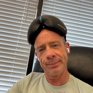 Man wearing headphones on his forehead in an office setting.