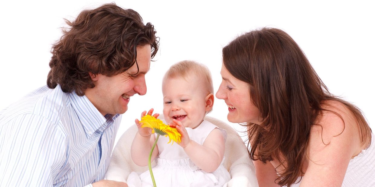 Happy father, mother and child with a yellow flower