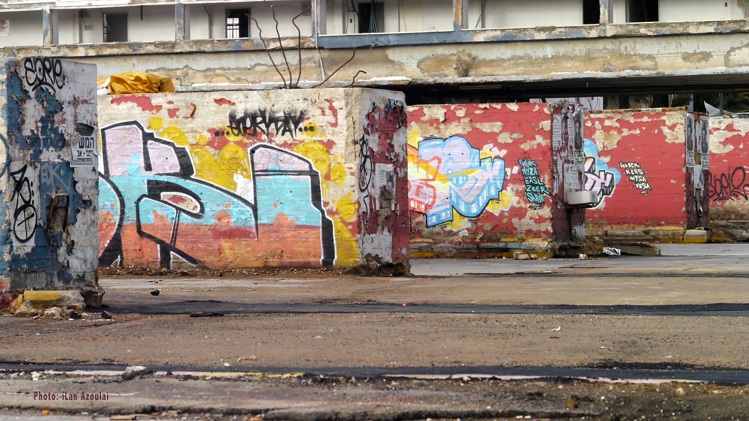 Abandoned urban space with colorful graffiti on decaying walls.