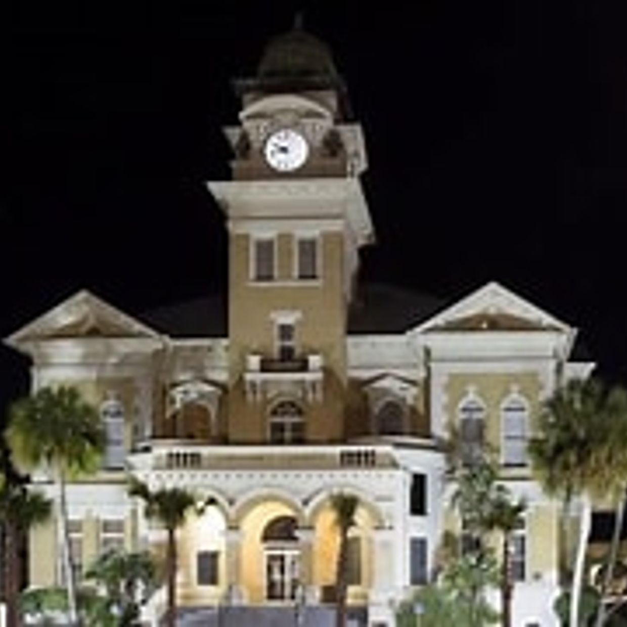 Historic clock tower building illuminated at night.