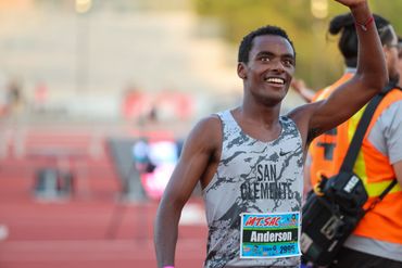 Smiling runner in a San Clemente uniform waves after a race.