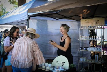 Women shopping at an outdoor market stall.