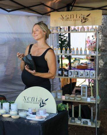 Pregnant woman selling curated goods at a market stall.