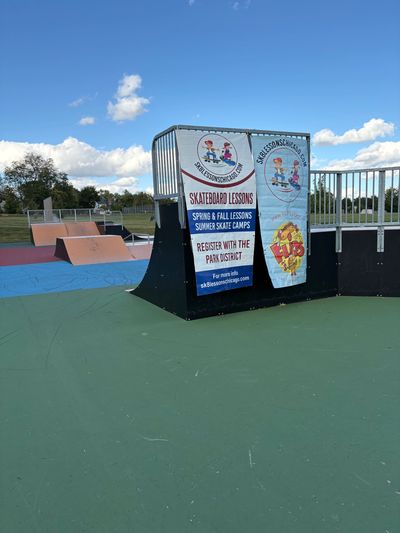Local business sponsor banners displayed at skatepark during SK8 Lessons Chicago youth lessons