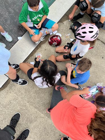 Students sharing skateboarding stickers at the end of Park Ridge Skateboard camp 